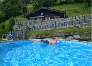 a man is laying in a swimming pool at Chalet Berger in Sankt Johann im Pongau