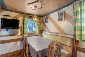 a dining room with a table and a tv at Chalet Berger in Sankt Johann im Pongau