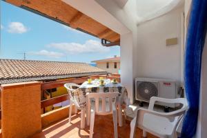 a balcony with a table and chairs on a roof at House Leoni in Isola Rossa