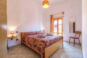 a bedroom with a bed and a table and a chair at House Leoni in Isola Rossa