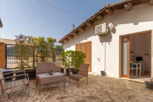 a patio with chairs and a table in front of a house at Villa Arianna in Ragusa