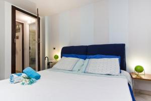 a bedroom with a bed with blue and white pillows at Casa Ginepro in Quartu SantʼElena +14 photos