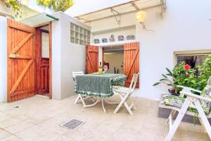 a patio with a table and chairs in front of a house at Casa Ginepro in Quartu SantʼElena