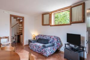 a living room with a couch and a tv at Villetta Allegra in Prataccio