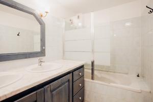 a bathroom with a sink and a tub and a mirror at Maison Conviviale 3 Vallées in Novallay