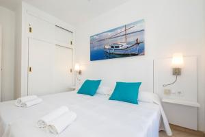 a bedroom with a white bed with blue pillows at Girasols Gardens Sup in Son Bou +15 photos
