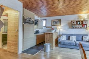 a living room with a blue couch and a kitchen at Gawal 1 in Villard-Reculas +8 photos