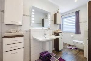 a white bathroom with a sink and a toilet at Ferienwohnung Sunny in Beckdorf +21 photos