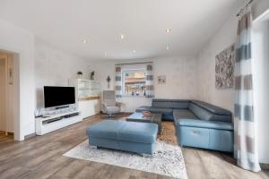 a living room with a blue couch and a tv at Ferienwohnung Sunny in Beckdorf