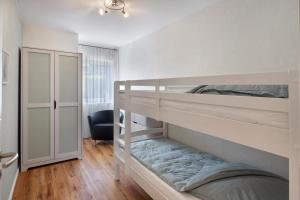 a bedroom with two bunk beds and a chair at Ferienwohnung Sunny in Beckdorf