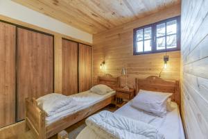 a bedroom with two beds in a wooden cabin at Gawal 1 in Villard-Reculas