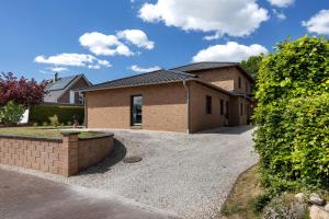a brick house with a driveway in front of it at Ferienwohnung Sunny in Beckdorf