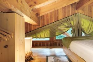 a bedroom in a log cabin with a bed at Baita Valon - Alpine Hideaway in Comano Terme