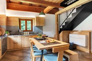 a kitchen with wooden cabinets and a wooden table at Baita Valon - Alpine Hideaway in Comano Terme