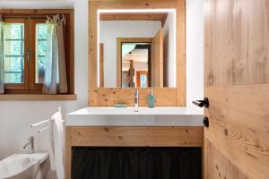 a bathroom with a white sink and a mirror at Baita Valon - Alpine Hideaway in Comano Terme +31 photos
