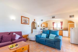 a living room with two blue couches and a kitchen at Casa Maravilla in Benitachell