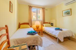 a bedroom with two beds and a window at Casa Maravilla in Benitachell +24 photos