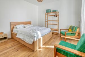 a bedroom with a bed and two chairs at Villa Lin et Maree face océan in Le Croisic