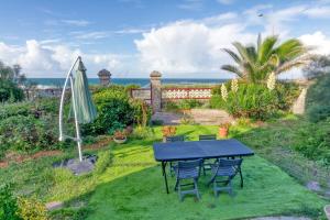a blue table and chairs in a yard with the ocean at Villa Lin et Maree face océan in Le Croisic