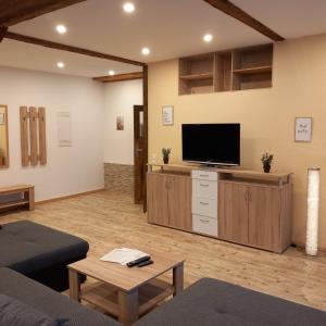 a living room with a flat screen tv and a couch at Ferienwohnung 1 Bartölke in Bockenem