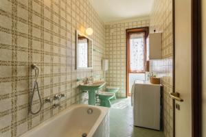a bathroom with a tub and a sink at Attico Panoramico in Brunate +14 photos