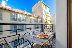 a table with a plate of food on a balcony at Appartement Sea View in Nice
