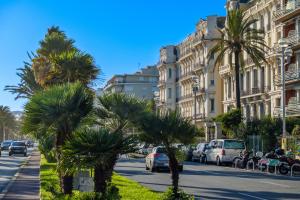 a street in a city with palm trees and cars at Appartement Sea View in Nice