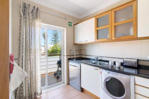a kitchen with a sink and a washing machine at Quinta Gomeira 69 in Cabanas de Tavira +13 photos