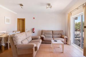 a living room with two couches and a table at Quinta Gomeira 69 in Cabanas de Tavira