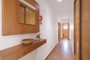 a hallway with a wooden shelf and a sink at Quinta Gomeira 69 in Cabanas de Tavira