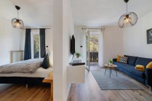 a living room with a bed and a blue couch at Appartment Riffl Anna in Rifiano