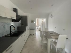 a kitchen with a sink and a table with chairs at Ferienwohnung Sonnenhöhe in Greiz