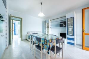 a kitchen with a dining room table and chairs at Residenza del Sole 1 in Villasimius