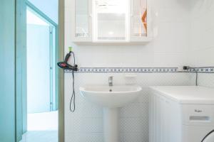 a white bathroom with a sink and a shower at Residenza del Sole 1 in Villasimius +15 photos