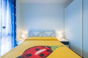 a bedroom with a bed with a lady bug pillow on it at Residenza del Sole 1 in Villasimius