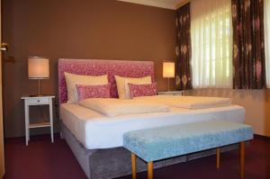 a bedroom with a large bed with a pink headboard at Der Ronacherfels in Weissensee