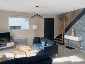 a living room with a blue couch and a staircase at Maison Ty Rhuys avec piscine in Saint-Gildas-de-Rhuys