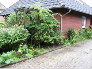 a garden in front of a red brick house at Ferienhaus Ockholm in Ockholm