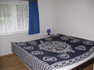 a bed with a black and white blanket on it at Ferienhaus Ockholm in Ockholm