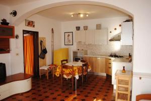 a kitchen with a table and chairs in a room at Appartamento Seccheto Mare in Seccheto