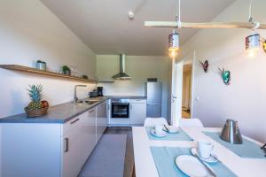 a kitchen with white cabinets and a counter top at Ferienwohnung Julia in Taching am See +11 photos