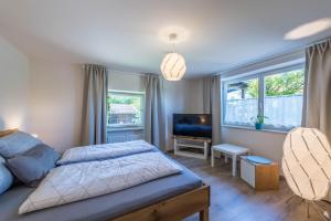 a bedroom with a bed and a desk and a television at Ferienwohnung Julia in Taching am See