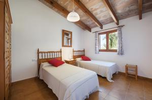 two beds in a room with white walls and a window at Can Toni in El Port +16 photos