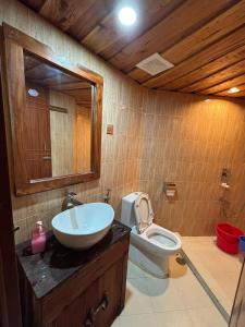 a bathroom with a sink and a toilet and a mirror at Bonomali Mangrove Resort in Dhāngmāri Forest Office