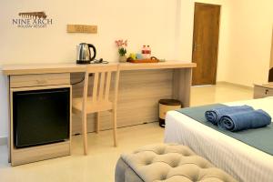 a bedroom with a desk with a television and a bed at Ella, Nine Arch Holiday Resort in Ella