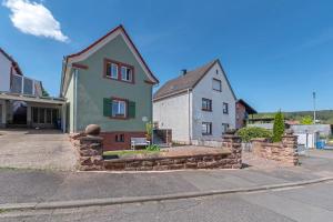 a house with a stone wall in front of a street at Grüner-Seppel in Rodalben