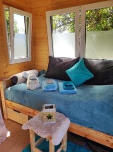a bed in a room with two windows at Mobile Tinyhouse by Wolfsberger in Mayrhof