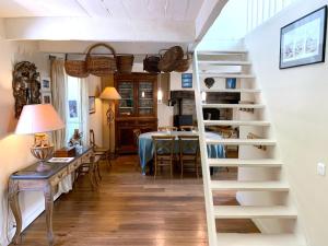 a spiral staircase in a living room with a table at Villa Kergariou in Clohars-Carnoët