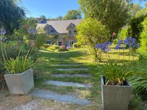a garden with two potted plants and a house at Villa Kergariou in Clohars-Carnoët