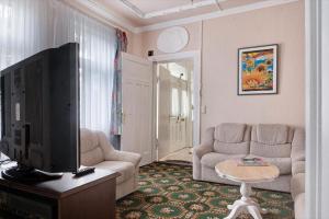 a living room with a flat screen tv and a couch at Die Kleine Ferienwohnung in Schneverdingen